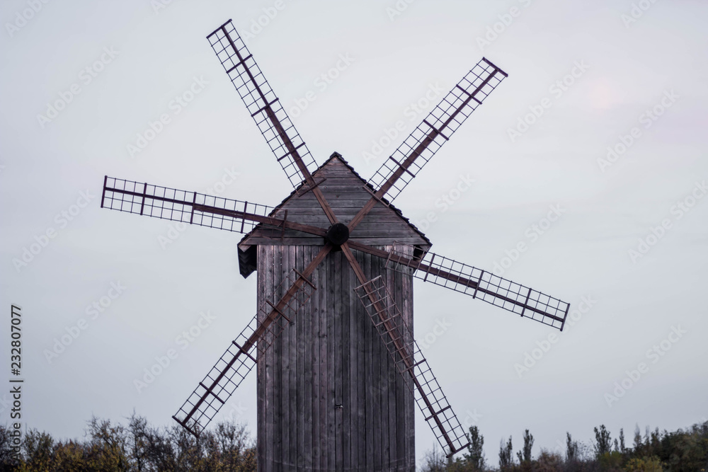 Wooden windmill in the field stands