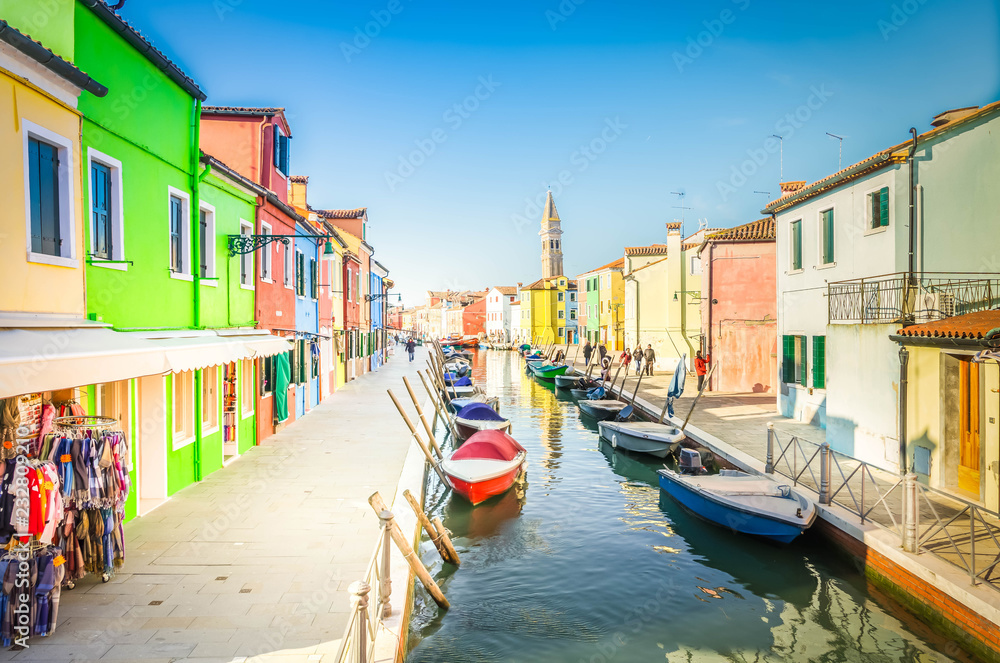 colorful rows of houses and boats of Burano island at sunny day, Venice, Italy, retro toned