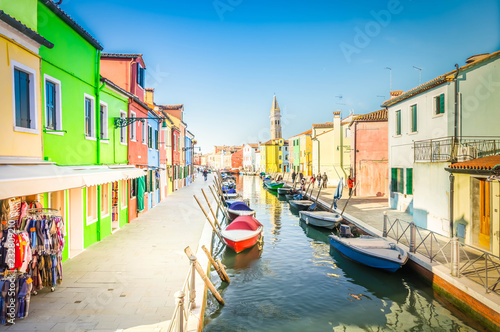 colorful rows of houses and boats of Burano island at sunny day, Venice, Italy, retro toned © neirfy