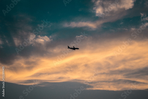 silhouette of a passenger plane on the background of sunset clouds
