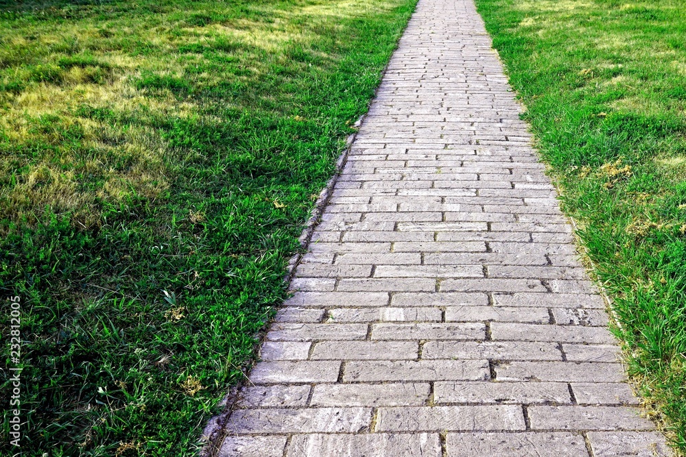Sidewalk. Straight path of granite gray cobblestone.