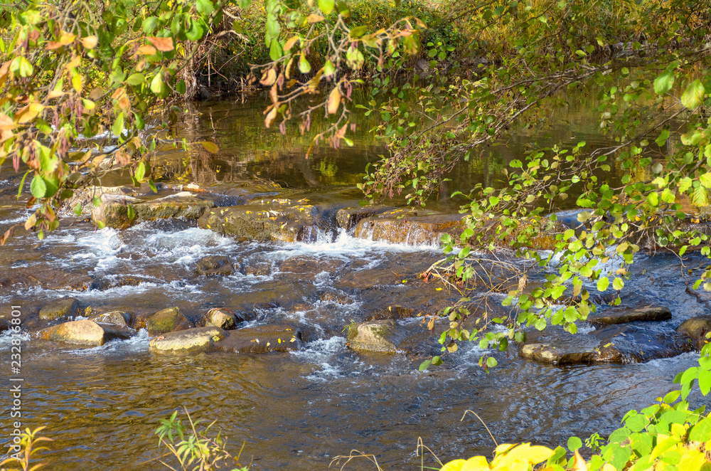 Picturesque waterfall on a fast flowing stream Picturesque waterfall on a fast flowing stream