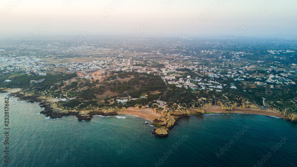 Naklejka premium Aerial view of sunset on the coast Algarve, Portugal. Concept for above Albufeira region beach of Portugal. Summer vacations