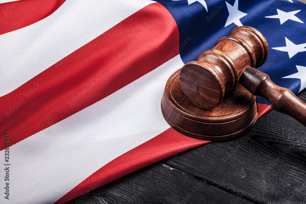Wooden gavel and USA flag on table close up