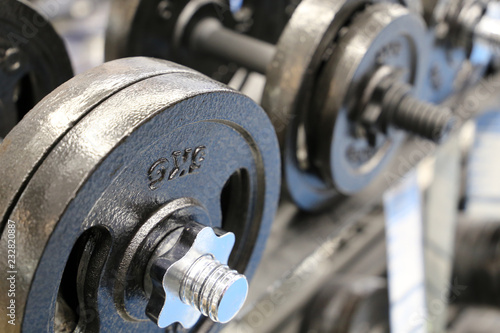 Metal dumbbells on rack in the gym, selective focus. Concept for weightlifting, bodybuilding, fitness center, sports
