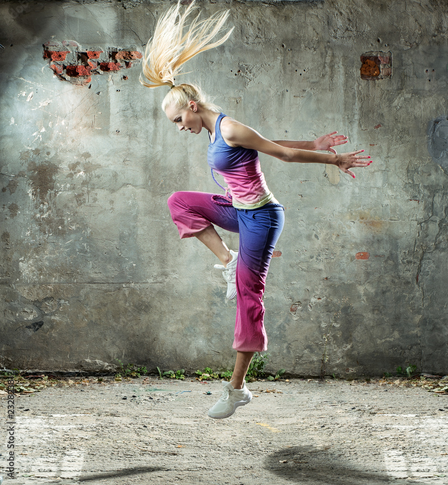 Fototapeta premium Pretty blond woman dancing in a grungy place