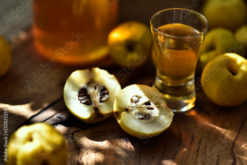 einture de coing d'or dans un verre à côté du fruit de coing