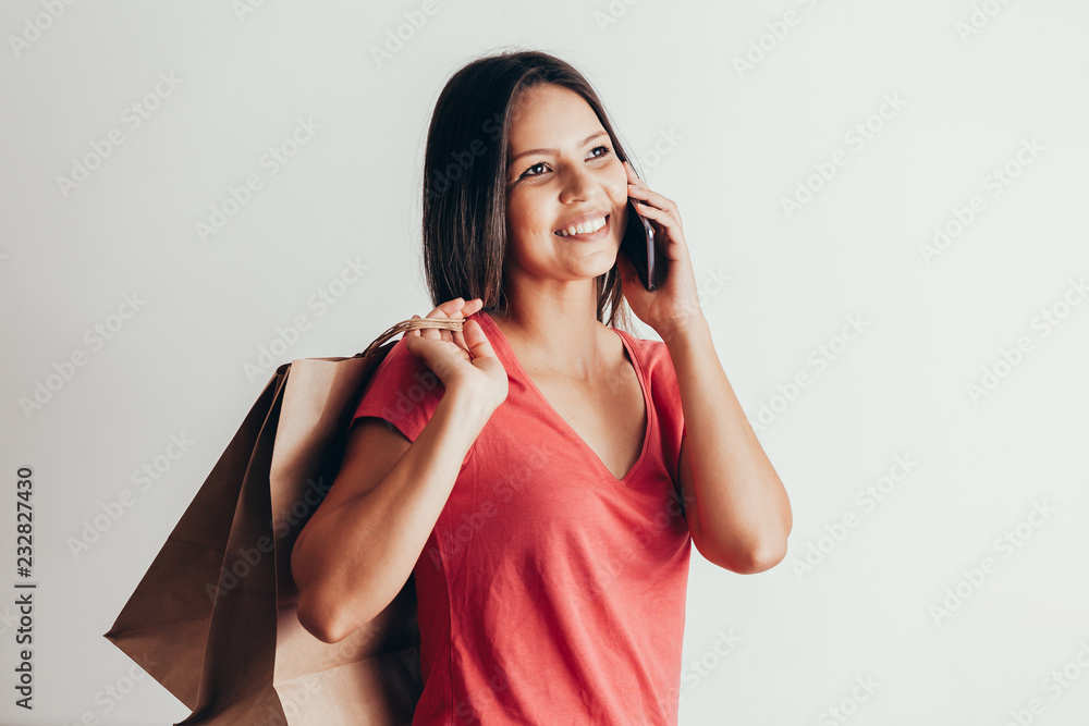 Woman shopping with a smart phone and carrying bags Woman shopping with a smart phone and carrying bags