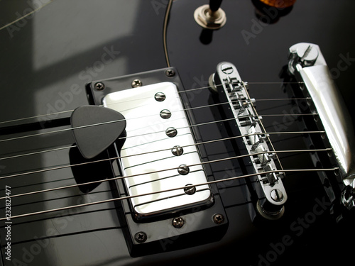 close up guitar pick and  black vintage electric jazz guitar