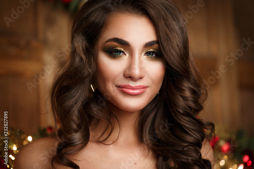 Portrait of a beautiful brunette woman with evening make-up and hairdo curls.