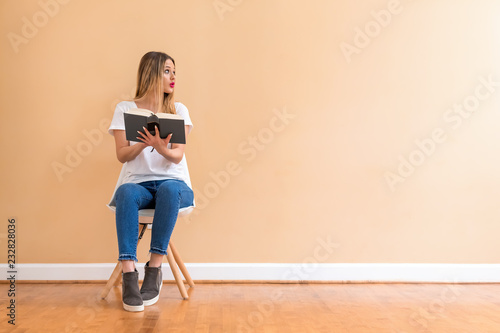 Young woman with a book in a chair