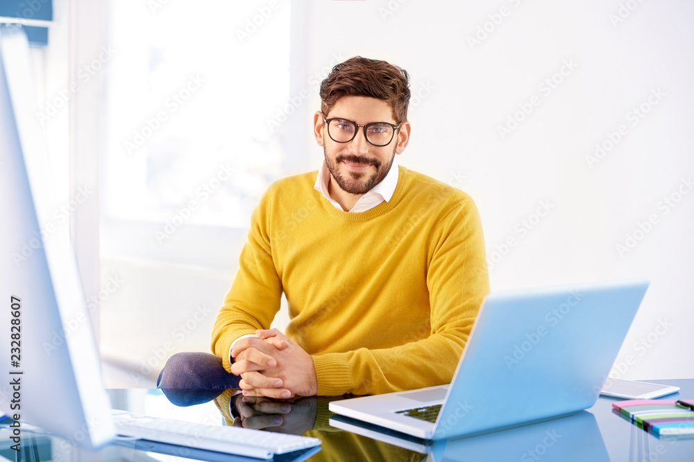 Handsome young man using laptop while working in the office Handsome young man using laptop while working in the office