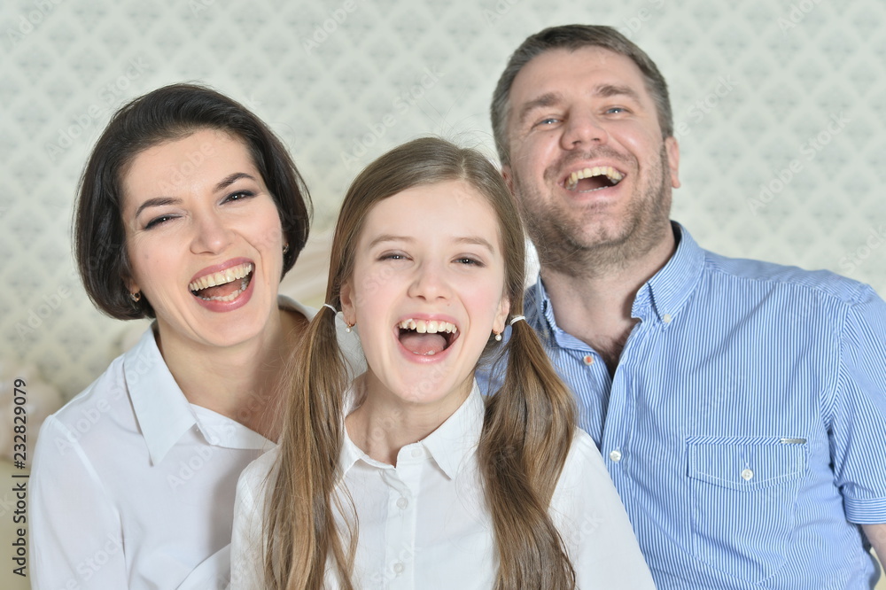Portrait of a beautiful parents and daughter posing in room Portrait of a beautiful parents and daughter posing in room