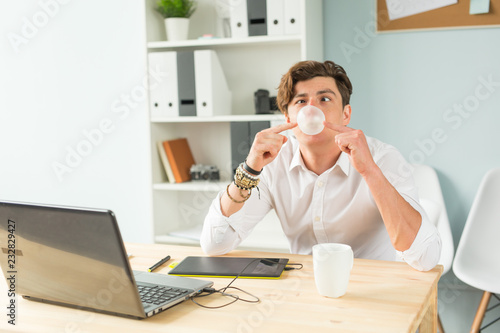 Fotografie Joke, office, humor, people concept - handsome man chewing gum and thinking abou