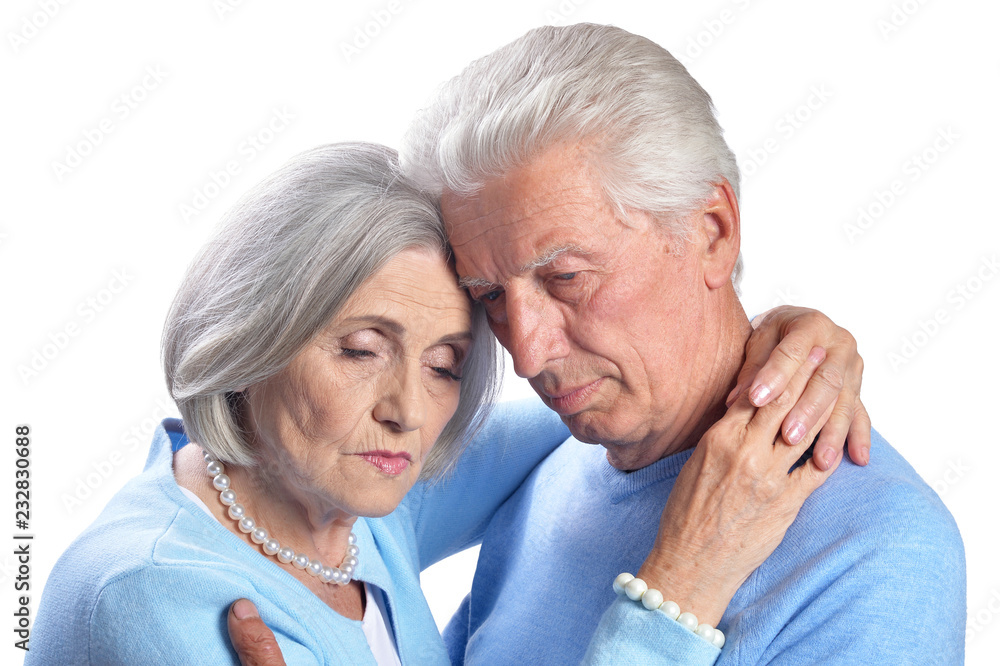 Portrait of sad senior couple hugging on white background Portrait of sad senior couple hugging on white background