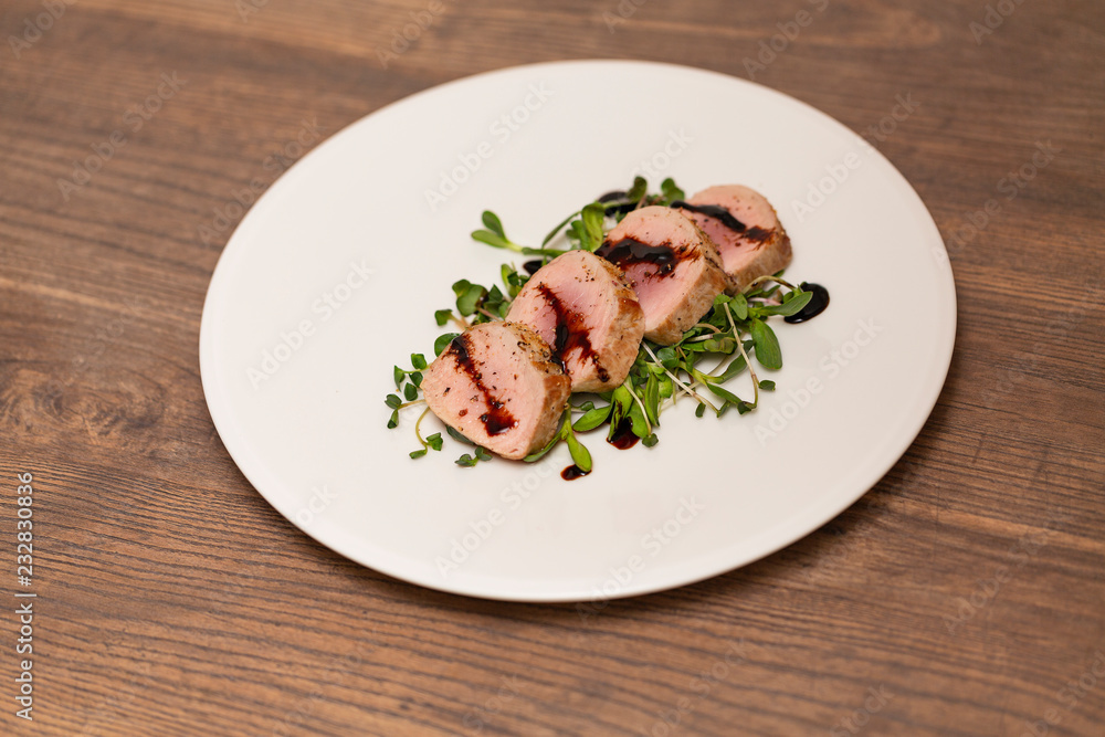 Hot Pork Tenderloin with Herbs and Spices on white plate with sauce. Selective focus. Food background Hot Pork Tenderloin with Herbs and Spices on white plate with sauce. Selective focus. Food background