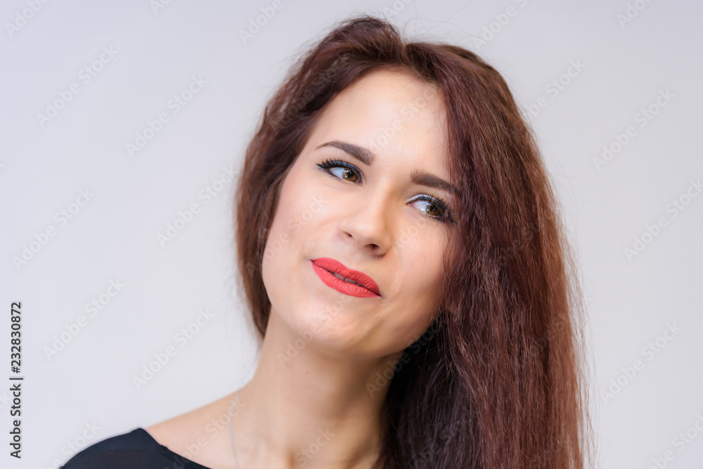 Studio portrait concept of a smiling beautiful brunette girl talking on a white background. Studio portrait concept of a smiling beautiful brunette girl talking on a white background.