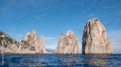 Sea stacks off the coast of Capri, Italy. They are named Stella, Faraglione di Mezzo with the arch, and Fraglione di Furori. © Lois GoBe