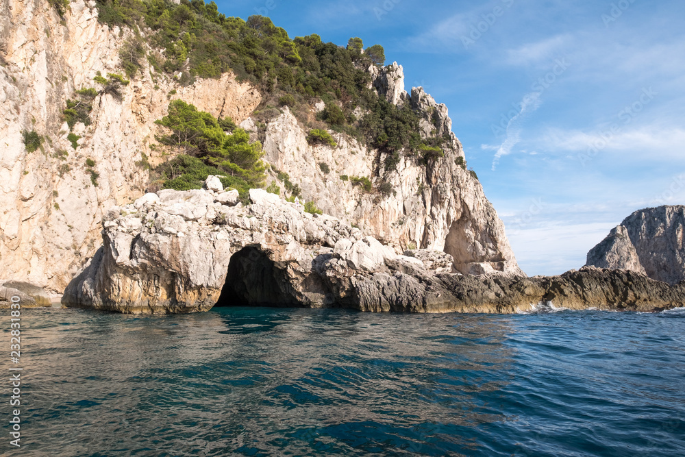 Caves in the cliffs on the island of Capri in the Bay of Naples, Italy. Photographed whilst on a boat trip around the island.