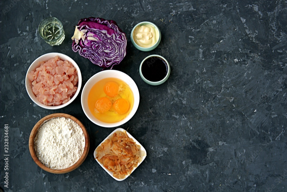 Ingredients for okonomiyaki, national Japanese dish: red cabbage, eggs, flour, mayonnaise, teriyaki sauce, sliced chicken fillet, tuna flakes, frying oil.
