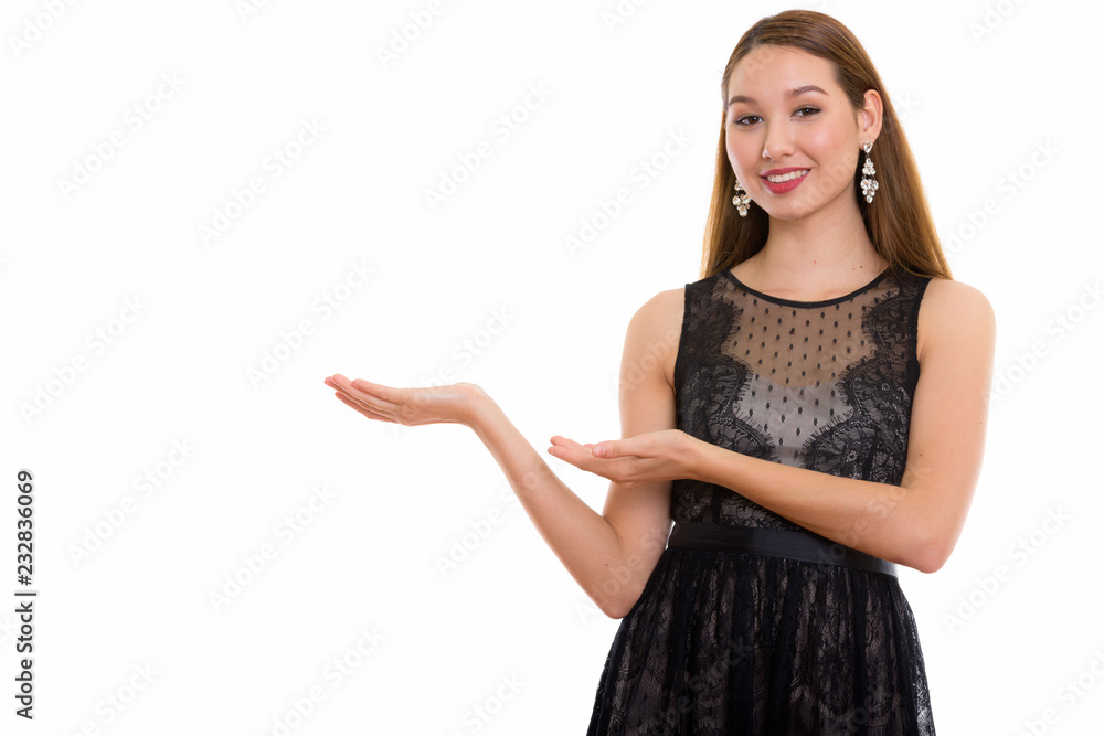 Studio shot of young happy beautiful Asian woman smiling and sho Studio shot of young happy beautiful Asian woman smiling and sho