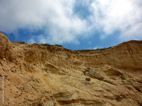 Eroded sandstone cliff rock formation against blue sky
