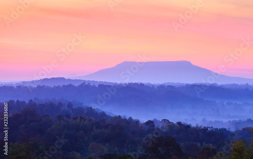 Dramatic sunrise sky over a blue mountain. © Tanes