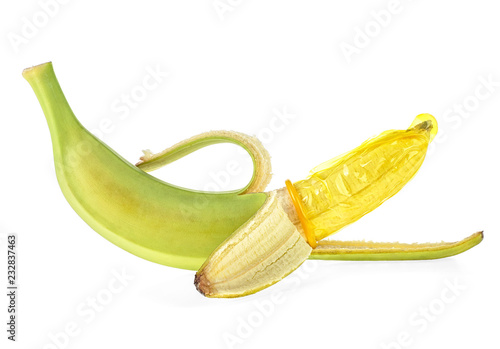 Green banana and yellow condom on white background