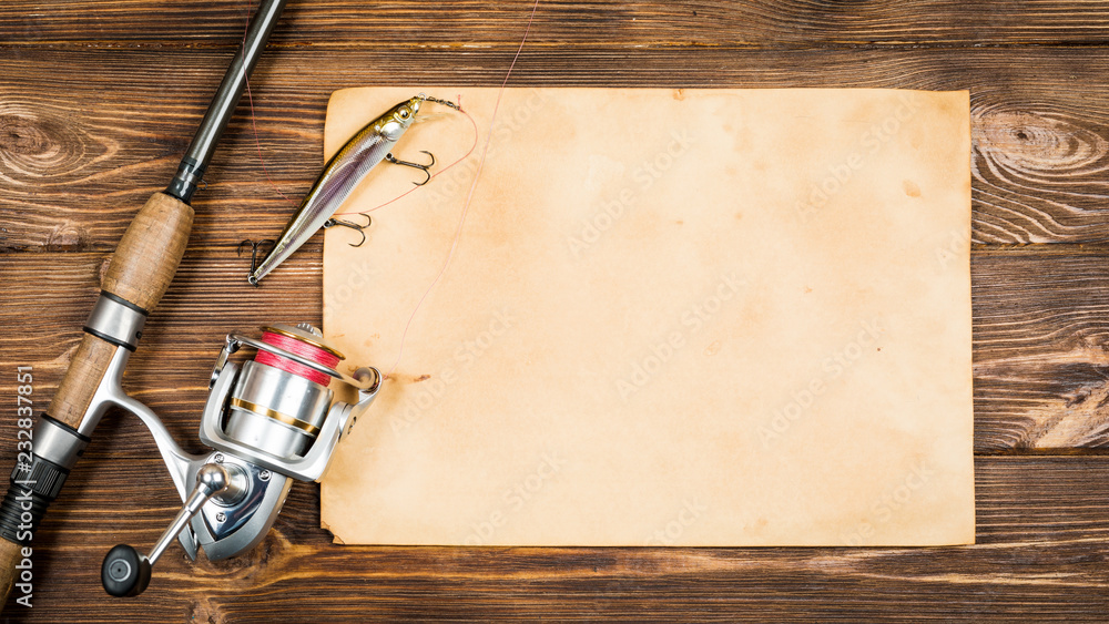 Fishing gear - fishing, hooks and baits, an old sheet paper on a wooden background. Toned Stock-foto Adobe Stock