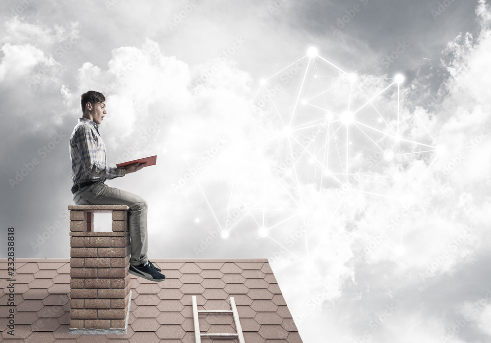 Man on brick roof reading book and concept of social connection Man on brick roof reading book and concept of social connection