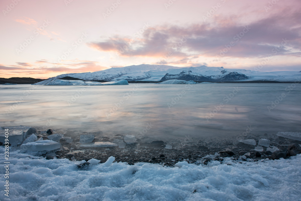 White snowy mountain on Svalbard, Norway. Ice in ocean, twilight in North pole. Pink clouds with ice floe. Beautiful landscape cold nature.