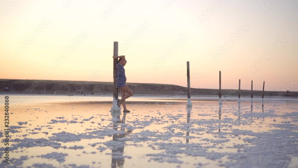 Calm girl enjoying sun, walking slowly through the water of a salt lake Calm girl enjoying sun, walking slowly through the water of a salt lake