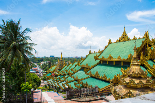 The roof of Eastern stairway of Shwedagon Zedi Daw and the lush green garden, occupying the slope of Singuttara Hill, Yangon, Myanmar.