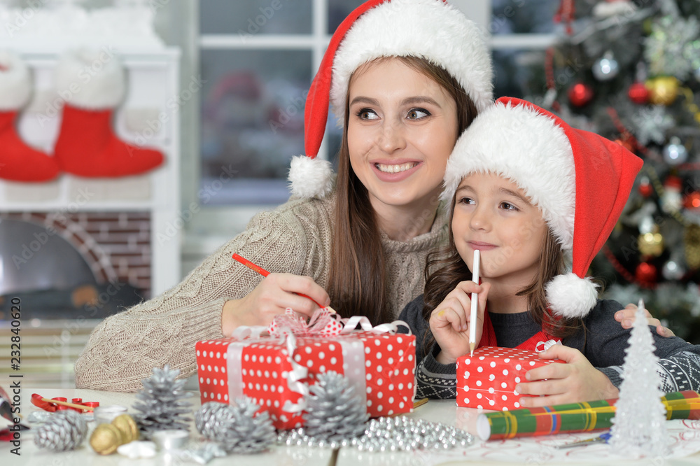 Portrait of smiling mother and daughter preparing for Christmas Portrait of smiling mother and daughter preparing for Christmas