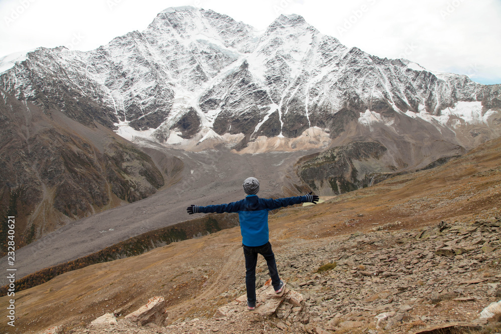 Naklejka premium Happy boy enjoying a magnificent mountain view
