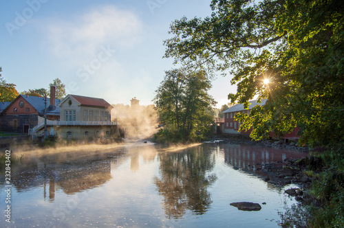 Countryside views and old watermill buildings in a misty sunrise