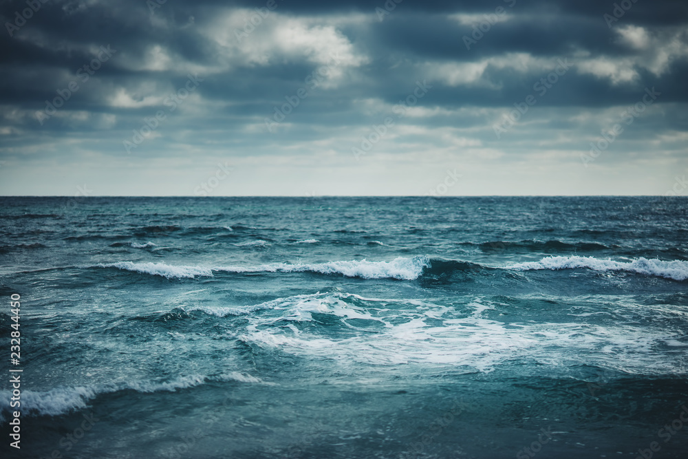 Water waves on cloudy sky background