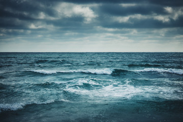 Fotobehang Oceaan golven Watergolven onder bewolkte hemel  © ValentinValkov