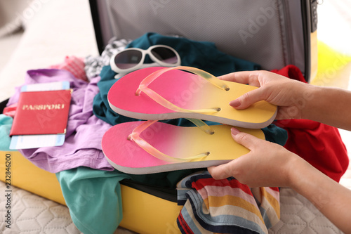 Woman packing suitcase for journey at home, closeup