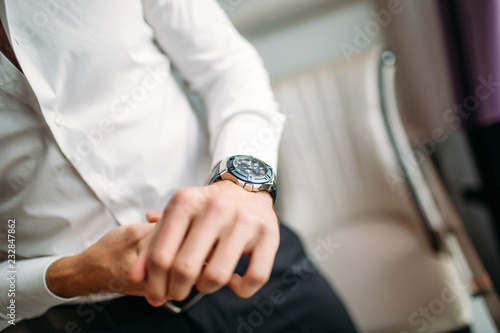 man with a watch buttons shirt