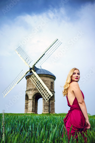 Young Blond Beautiful Adult Female Model posing in front of famous heritage Chesterton Windmill in Warwickshire, UK photo