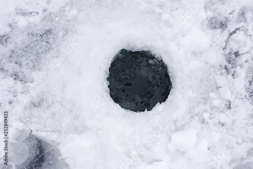 the hole in the ice for ice fishing photo