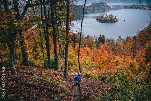 Athlete run in autumn forest by bled lake in Slovenia. famous and very popular landmark and travel destination. Fall scenery photo