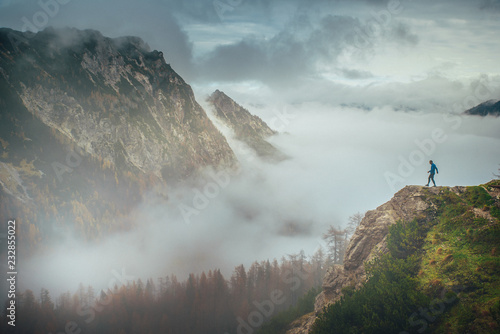 Tourist looking to the valley on misty autumn landscape. Julian Alps, Slovenia