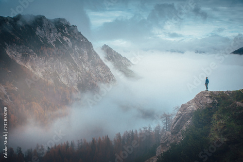 Hiker in autumn misty Alps photo