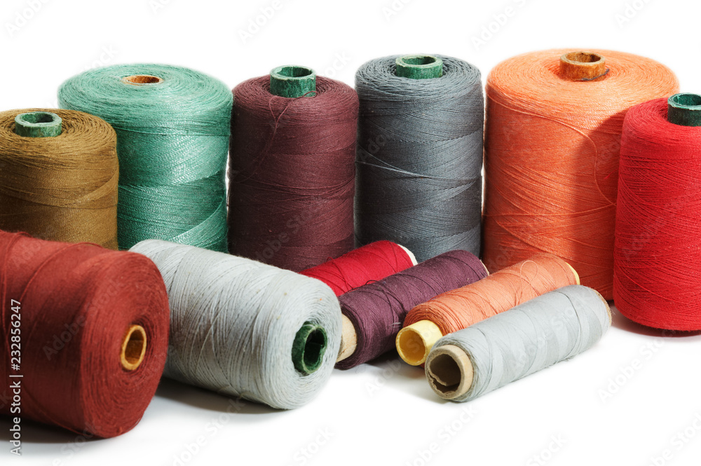 Several sewing spools of various color on white background, isolated, closeup Several sewing spools of various color on white background, isolated, closeup