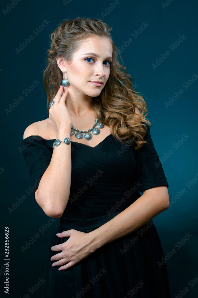 Beautiful young model with earrings necklace and ring on dark background Beautiful young model with earrings necklace and ring on dark background