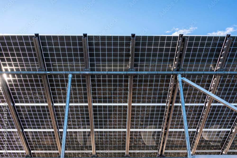 Close up of underside of solar panel installation with a blue sky background