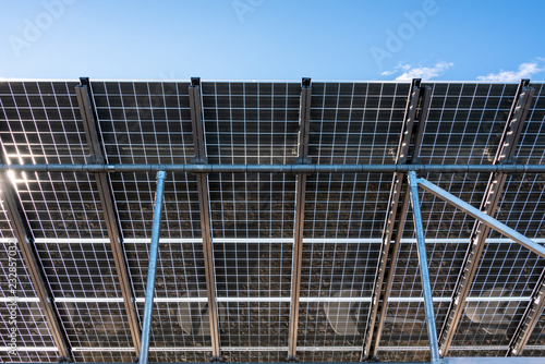 Close up of underside of solar panel installation with a blue sky background