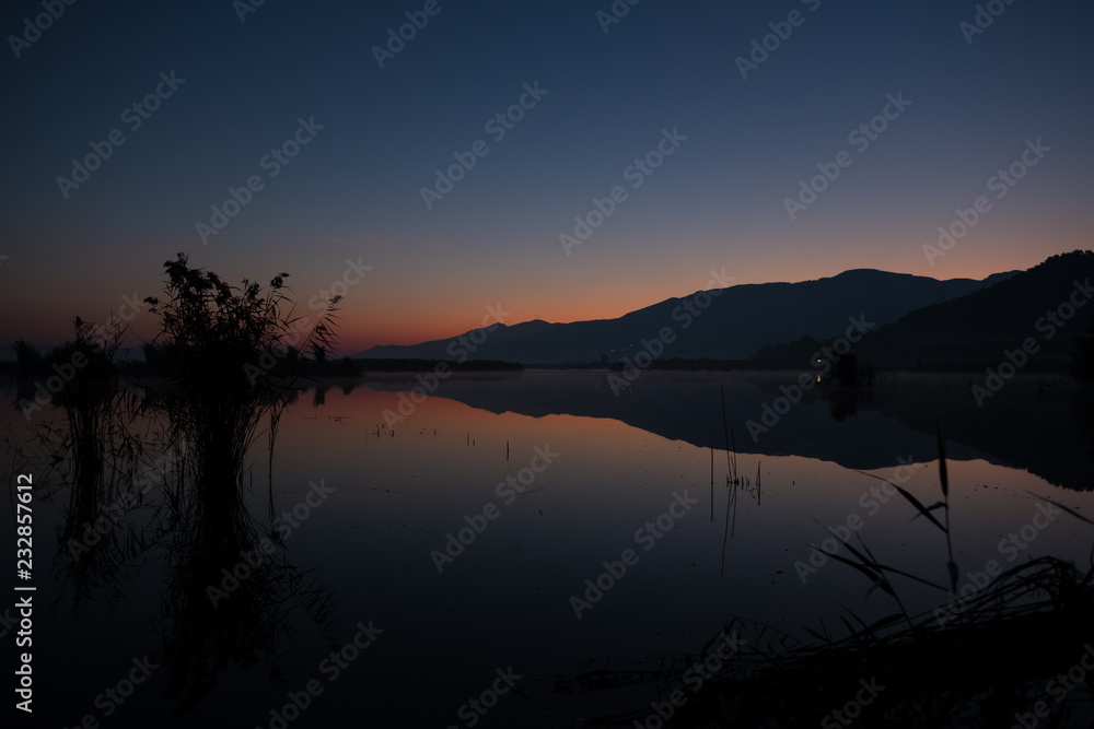 Silhouettes of Reeds and Hills Before Sunrise